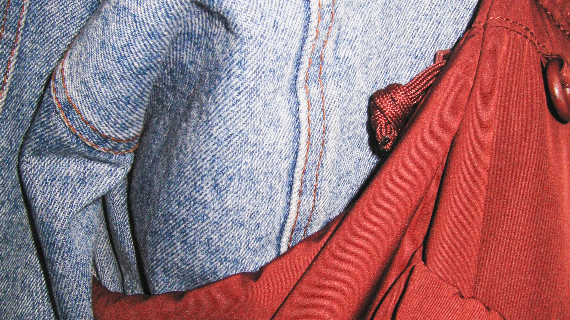 Photographie de mode en gros plan : détail d'un jean et d'un sac en tissu rouge